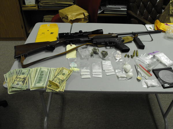 A gun, money, various drugs, and paraphernalia.